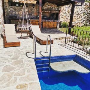 a patio with a swing and a swimming pool at Old stone house with swimming pool Etno House Perazic in Bar