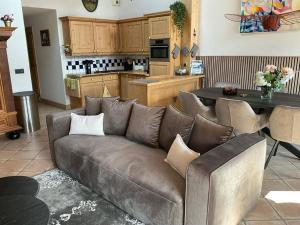 a living room with a couch and a kitchen at Spacieux chalet 8 pers avec piscine, spa et pied des pistes - 3 étoiles Atout France - FR-1-461-21 in Saint-Martin-de-Belleville