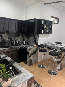 a kitchen with black cabinets and a counter with stools at Wilson's Guest House in Nilwella +11 photos