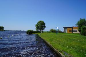 a body of water with a building in the background at EuroParcs Kagerplassen in Warmond