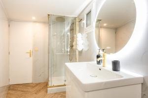 a white bathroom with a sink and a shower at Modern Souplex with Air Conditioning and Hot Tub I Central location in Paris