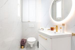 a white bathroom with a sink and a mirror at Modern Souplex with Air Conditioning and Hot Tub I Central location in Paris +10 photos