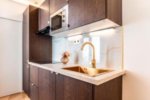 a kitchen with a sink and a microwave at Modern Souplex with Air Conditioning and Hot Tub I Central location in Paris