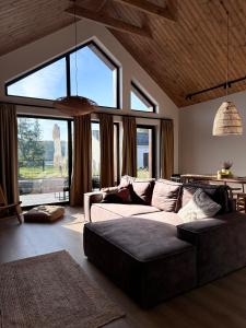 a living room with a couch and a large window at Stodoły Trzy Żywioły in Prusim