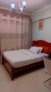 Un dormitorio con una cama y una lámpara de araña. en Super Paradise Hotel, en Kampala 29 fotos más