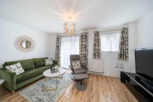 a living room with a green couch and a tv at Chic House With Parking And Private Garden in Northfleet