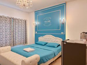 a bedroom with a bed and a blue wall at TheHill Resort เลาขวัญ in Ban Nong Masang +8 photos