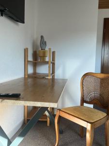 a wooden table and a chair with a plant on a shelf at Zentrales und ruhiges Reiheneckhaus, 4,5 Zimmer in Köngen