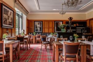 ein Restaurant mit Tischen und Stühlen und einem Kronleuchter in der Unterkunft Hotel Golfi in Poděbrady