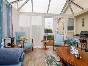 a living room with blue chairs and a table at Tataramoa in Penryn