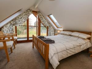 Un dormitorio con una cama y una ventana grande. en Little Dairy House, en Swanage