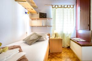a small bedroom with a bed and a window at Apartman Antonio in Dubrovnik