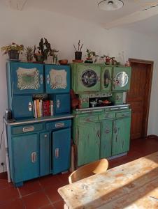 a kitchen with blue and green cabinets and a table at Chez Olive et Garance in Couret +23 photos
