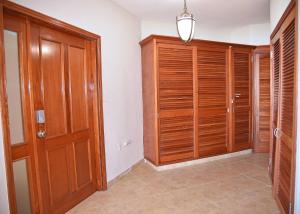 un pasillo con armarios de madera y una puerta en una habitación en Oceanfront Paradise: Penthouse with Peloton, en Lowlands 49 fotos más