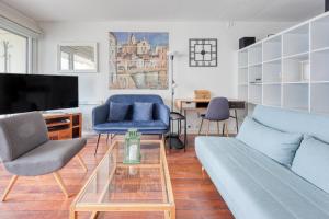 ein Wohnzimmer mit Sofa, Sesseln und Fernseher in der Unterkunft Katikias - Duplex climatisé vue mer in Bandol