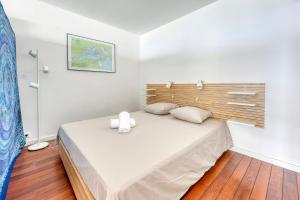 ein Schlafzimmer mit einem großen Bett mit einem hölzernen Kopfteil in der Unterkunft Katikias - Duplex climatisé vue mer in Bandol + 8 Fotos