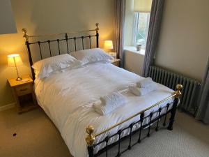 ein Schlafzimmer mit einem großen Bett mit weißen Laken und Kissen in der Unterkunft Riverside Cottage with secure bike storage in Staveley