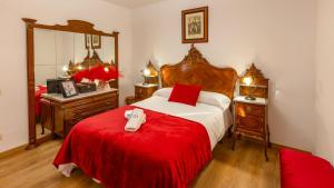 a bedroom with a bed with a red blanket and a mirror at La Fuente Romana Priego de Córdoba by Ruralidays in Priego de Córdoba +17 photos