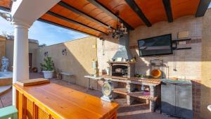 an outdoor patio with a wooden table and a television at La Fuente Romana Priego de Córdoba by Ruralidays in Priego de Córdoba