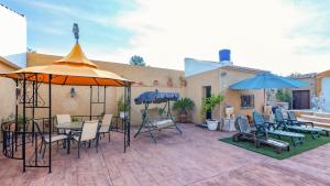 a patio with tables and chairs and umbrellas at La Fuente Romana Priego de Córdoba by Ruralidays in Priego de Córdoba