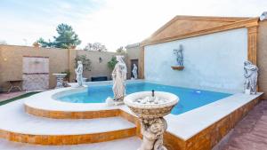 a large pool with a fountain in a courtyard at La Fuente Romana Priego de Córdoba by Ruralidays in Priego de Córdoba