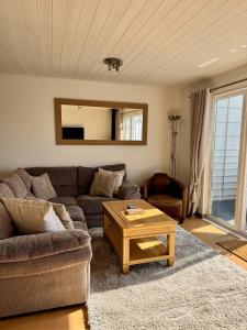 a living room with a couch and a coffee table at Medway Hot Tub Lodge in South Cerney