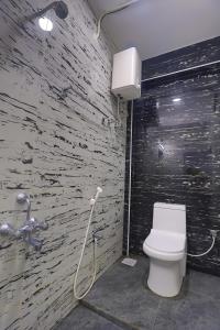 a bathroom with a white toilet and a shower at AN Hotel chennai airport in Chennai