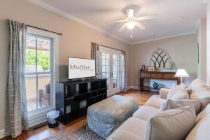 a living room with a couch and a flat screen tv at Pearl of the Promenade in Bluffton
