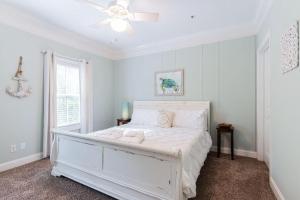 a bedroom with a white bed and a ceiling fan at Pearl of the Promenade in Bluffton