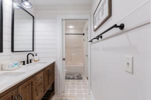 a white bathroom with a sink and a mirror at Pearl of the Promenade in Bluffton +28 photos