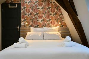 una camera da letto con un letto con asciugamani sopra di Duplex Rue Royale, rooftop, balnéo spa a Lille