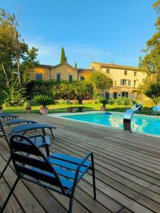 une paire de bancs assis sur une terrasse près d'une piscine dans l'établissement La villa des figuiers, à Saint-Bonnet-du-Gard