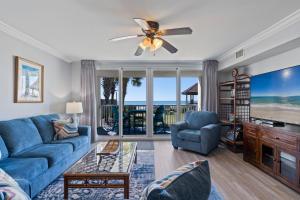 a living room with a blue couch and a table at Romar Tower Unit 1A in Orange Beach