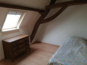 Un dormitorio con una cama y una cómoda y una ventana. en Duplex, en Ronse