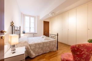 une chambre avec un lit et une chaise dans l'établissement Large Apartment in the Historic Center of Parma, à Parme