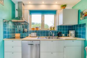 a kitchen with a sink and a window at Vakantiehuis, Villapark Oesterbaai 39, aan zee, grenzend aan speeltuin in Wemeldinge