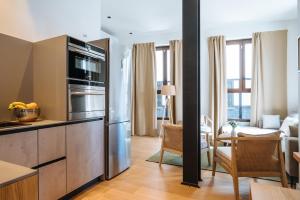 eine Küche mit Küchengeräten aus Edelstahl und ein Wohnzimmer in der Unterkunft Al Sur Home in Sevilla