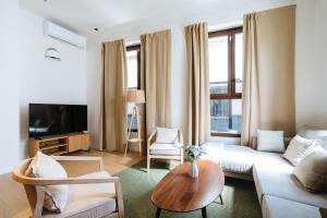 ein Wohnzimmer mit Sofa und Tisch in der Unterkunft Al Sur Home in Sevilla