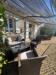 eine Terrasse mit Korbstühlen und einem Glastisch in der Unterkunft Comfort studio, fully equipped! in Saint-Paul-de-Vence