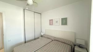 biała sypialnia z łóżkiem z narzutą do łóżka w obiekcie Apartamentos Esmeralda Unitursa w mieście Calpe +37 zdjęć