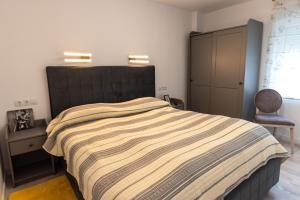 a bedroom with a large bed and a chair at Tudor Central Apartment in Bistriţa