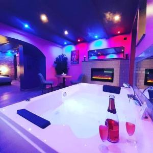 a room with a bath tub with a sink and a fireplace at L'art du désir in Le Saulcy