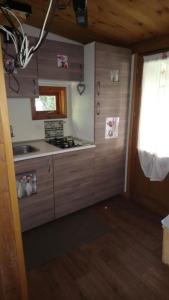 una cucina con mobili in legno e un forno a piano cottura di Campeggio Punta di Crabbia a Pettenasco