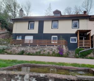 a house with a pond in front of it at L'art du désir in Le Saulcy
