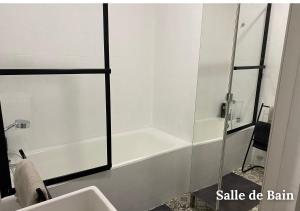 ein Badezimmer mit einer weißen Badewanne neben einem Waschbecken in der Unterkunft Maison Le Balcon du Lac in Les Salles-sur-Verdon