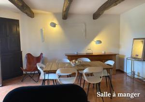 ein Esszimmer mit einem Holztisch und Stühlen in der Unterkunft Maison Le Balcon du Lac in Les Salles-sur-Verdon + 9 Fotos