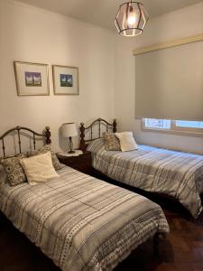 une chambre avec deux lits et une lampe et une fenêtre dans l'établissement En el corazón de mendoza - Amplio departamento, à Mendoza