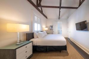 una camera da letto con un letto e una televisione di Melrose Mansion a New Orleans Altre 81 foto