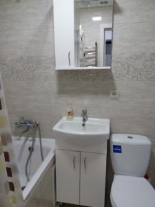 a bathroom with a sink and a toilet and a bath tub at Квартира студія в центрі міста Філармонія in Khmelʼnytsʼkyy