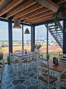 a restaurant with tables and chairs and a view of the beach at Prachtig appartement midden op Jachthaven Zeeland VP018 in Bruinisse